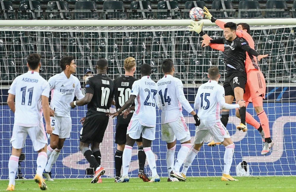 Moenchengladbach’s Algerian defender Ramy Bensebaini and Real Madrid’s goalkeeper Thibaut Courtois vie for the ball during a recent football match. File/AFP