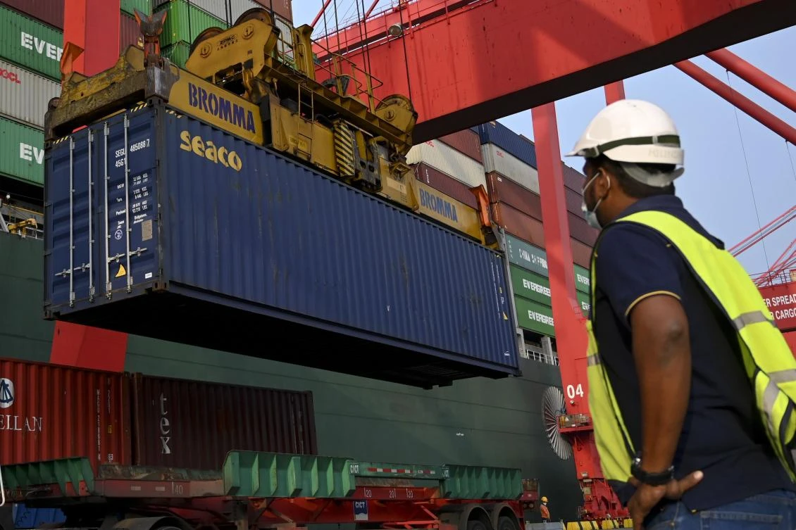 Sri Lankan authorities load containers of garbage, allegedly including hospital waste, to be taken back to Britain, from where they had been sent illegally to Sri Lanka, in Colombo on October 30, 2020. (AFP)