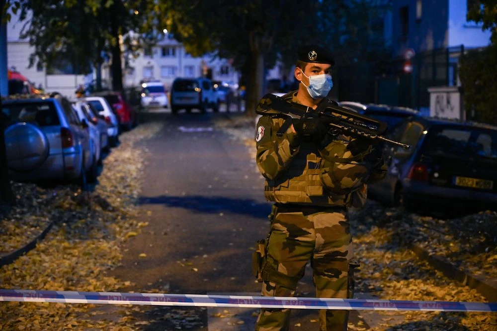 A French soldier stands behind a cordon on October 31, 2020 in Lyon near the scene where an attacker armed with a sawn-off shotgun wounded an Orthodox priest in a shooting before fleeing, said a police source. The priest, who has Greek nationality, was closing his church when the attack happened and is now in a serious condition, said the source, who asked not to be named. (AFP)