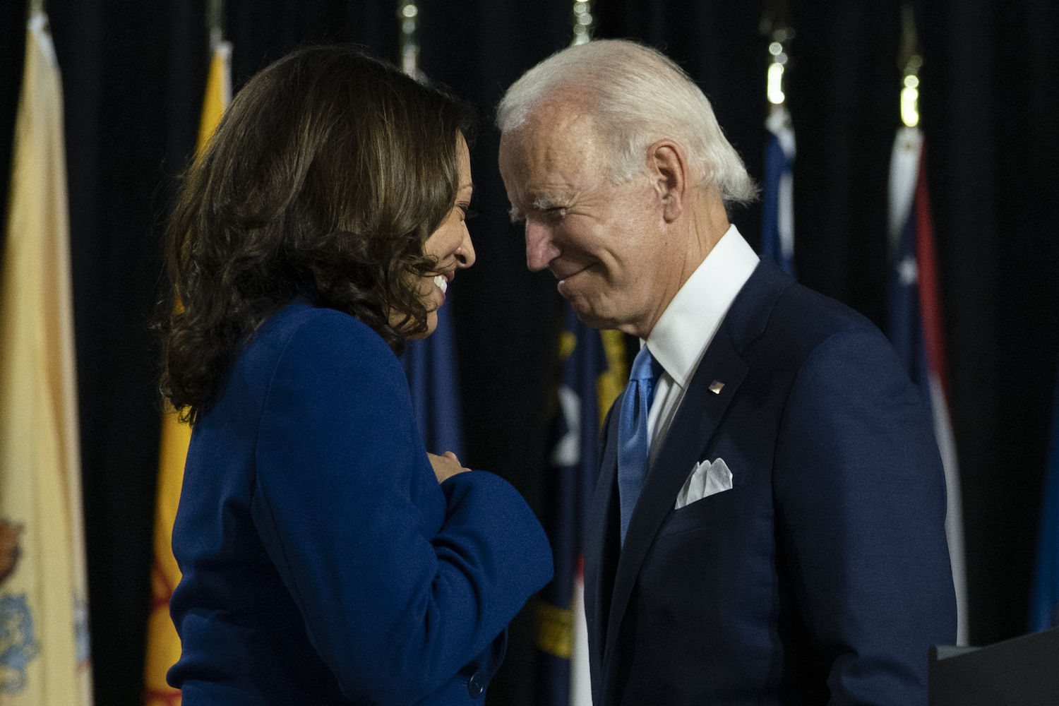 Joe Biden and Kamala Harris pass each other as Harris moves to the podium to speak during a campaign event at Alexis Dupont High School in Wilmington. (File/AP)