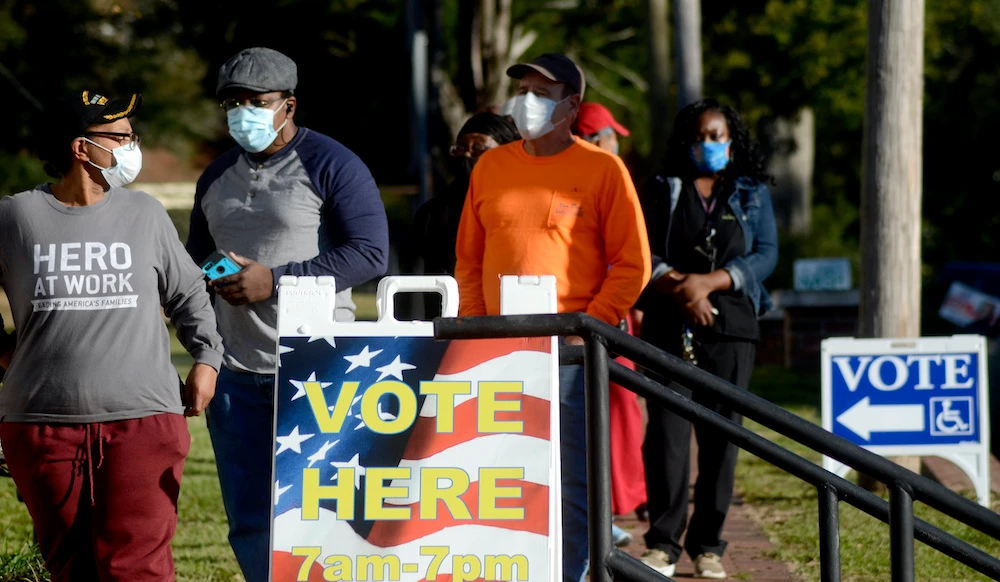 Voters stand in line outside town hall on Election Day, in Summit, Mississippi, on Tuesday, Nov. 3, 2020. (The Enterprise-Journal via AP)