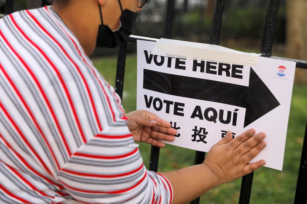 An election worker posts signage outside a polling station at the James Weldon Johnson Community Center on Election Day in Harlem in the Manhattan borough of New York City, New York, U.S., Nov. 3, 2020. (Reuters)