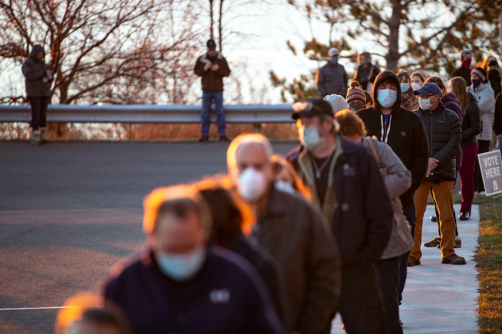 A long line of voters forms outside of First United Methodist Church as the sun rose over Lake Superior in Duluth, Minnesota, on Election Day, Tuesday, Nov. 3, 2020. (Star Tribune via AP)