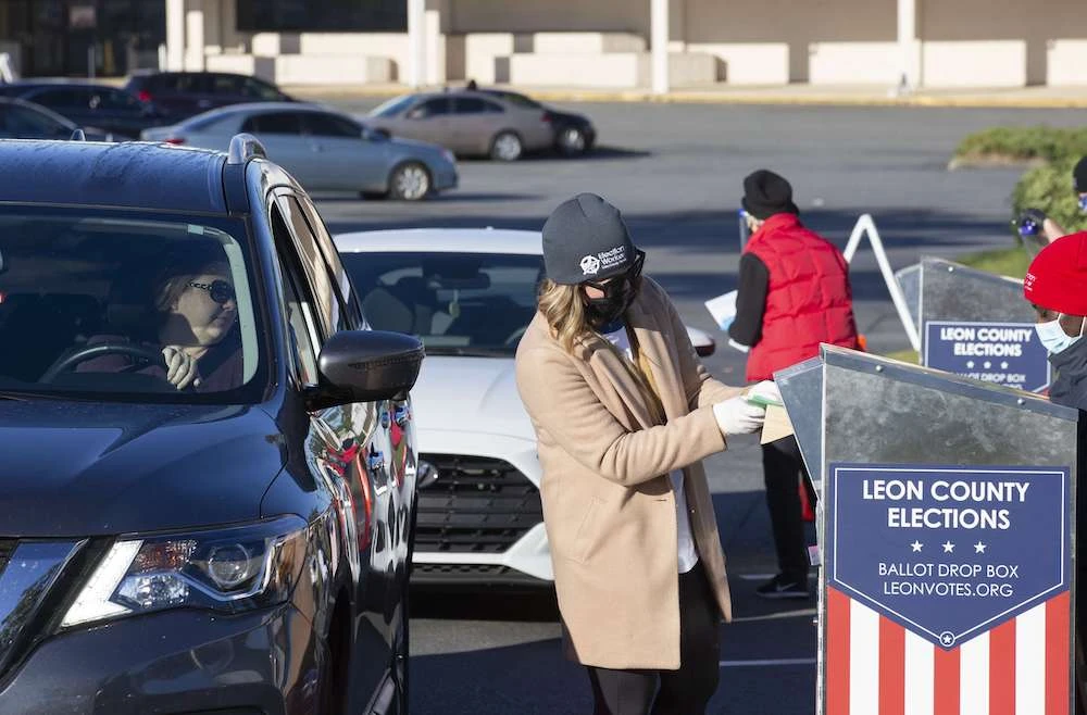 Volunteer poll worker Kirsten Phelps, center, accepts a mail ballot at a drop off site outside the Leon County Supervisor of Elections office on November 3, 2020 in Tallahassee, Florida. (Getty Images/AFP)