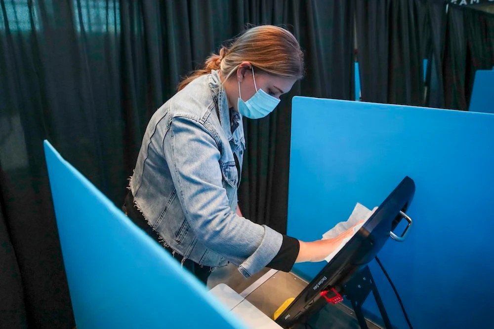 Meghan Pollock cleans the polling station during election day at the United Center in Chicago, Illinois, on Nov. 3, 2020. (AFP)