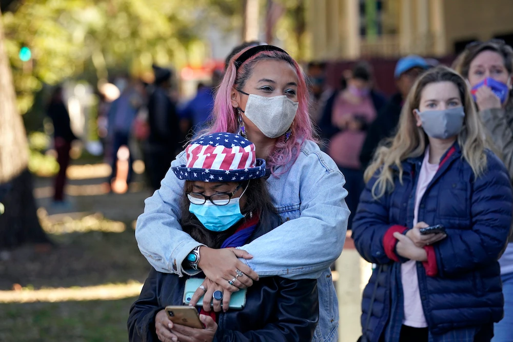 Erin Doherty hugs her mother Susanna Dew, 61, who is voting for the first time in her life, as they wait in line at a polling place on election day in the Mid City section of New Orleans, Tuesday, Nov. 3, 2020. (AP)