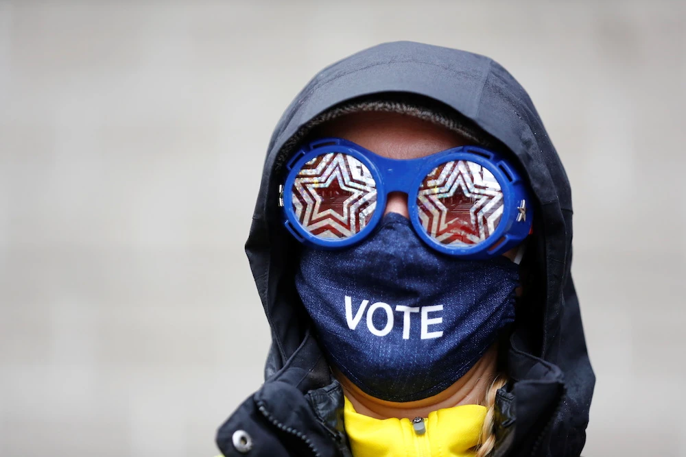 Cesia Kearns wearing glasses and a face mask is seen outside a polling place in the CenturyLink Field Event Center on Election Day, in Seattle, Washington, US Nov. 3, 2020. (Reuters)
