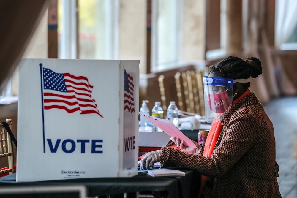 A poll worker sorts through voting material at Park Tavern in Atlanta on Tuesday, Nov. 3, 2020. (Atlanta Journal-Constitution via AP)