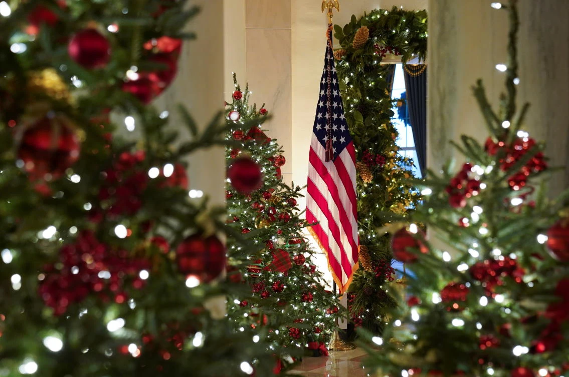 A U.S. flag is seen through holiday decorations in the Cross Hall of the White House in Washington, U.S., November 30, 2020. REUTERS/Kevin Lamarque