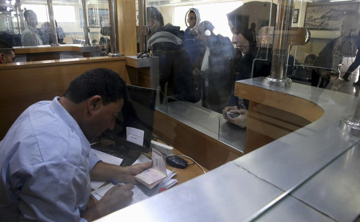 A passport control officer of the Palestinian Authority stamps passports of passengers on their way to cross the border to the Egyptian side of Rafah crossing with Egypt, in Rafah, Gaza Strip. (AP)