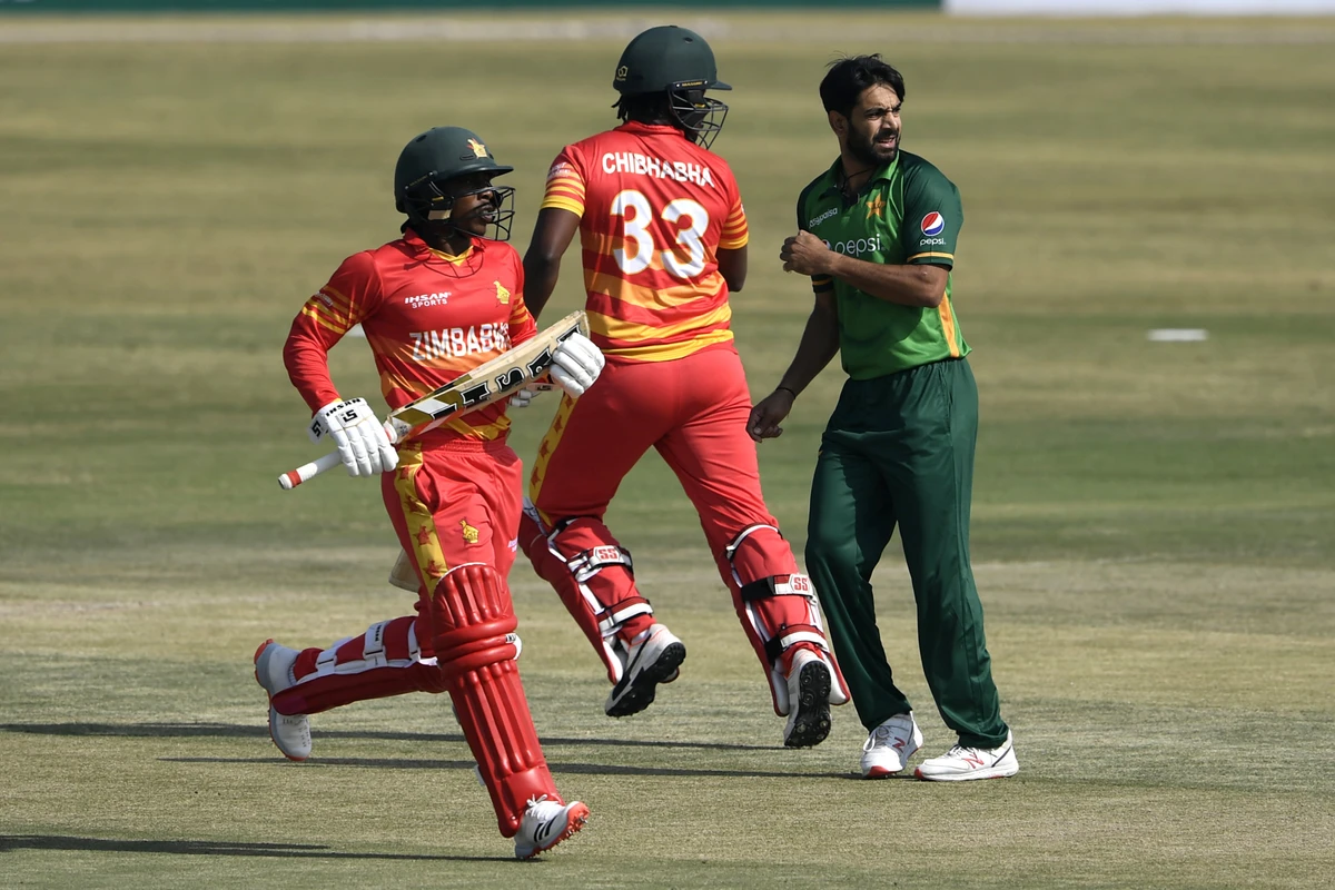 Zimbabwe's captain Chamu Chibhabha (C) and teammate Brian Chari (L) run between the wickets as Pakistn's Haris Rauf (R) looks on during the second one-day international (ODI) cricket match between Pakistan and Zimbabwe at the Rawalpindi Cricket Stadium in Rawalpindi on November 1, 2020. (AFP)