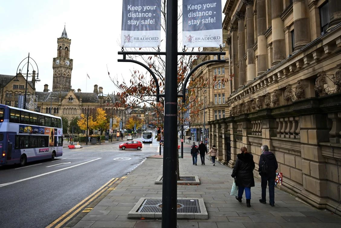 Shoppers walk along a near-deserted street in the centre of Bradford, west Yorkshire on October 31, 2020, as the number of cases of the novel coronavirus COVID-19 rises. (AFP)
