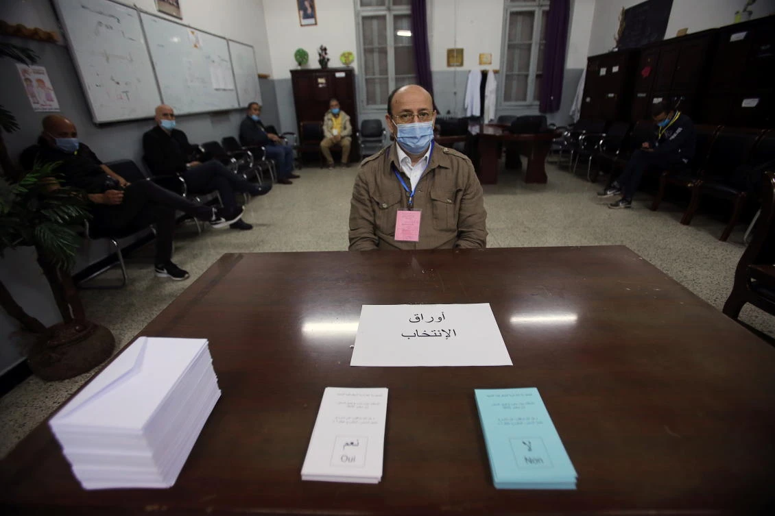 An electoral worker wearing a face mask for protection against the coronavirus disease (COVID-19), looks on at a polling station where Algerians vote in a constitutional referendum in Algiers, Algeria November 1, 2020. (Reuters)