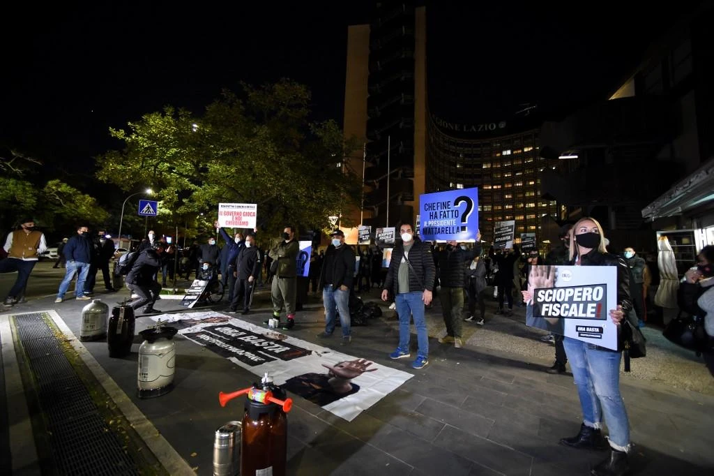 Above, owners of pubs, bars, restaurant affected by the measures to contain the coronavirus protest in front of the Regione Lazio headquarters in Rome on Oct. 28, 2020. (AFP)