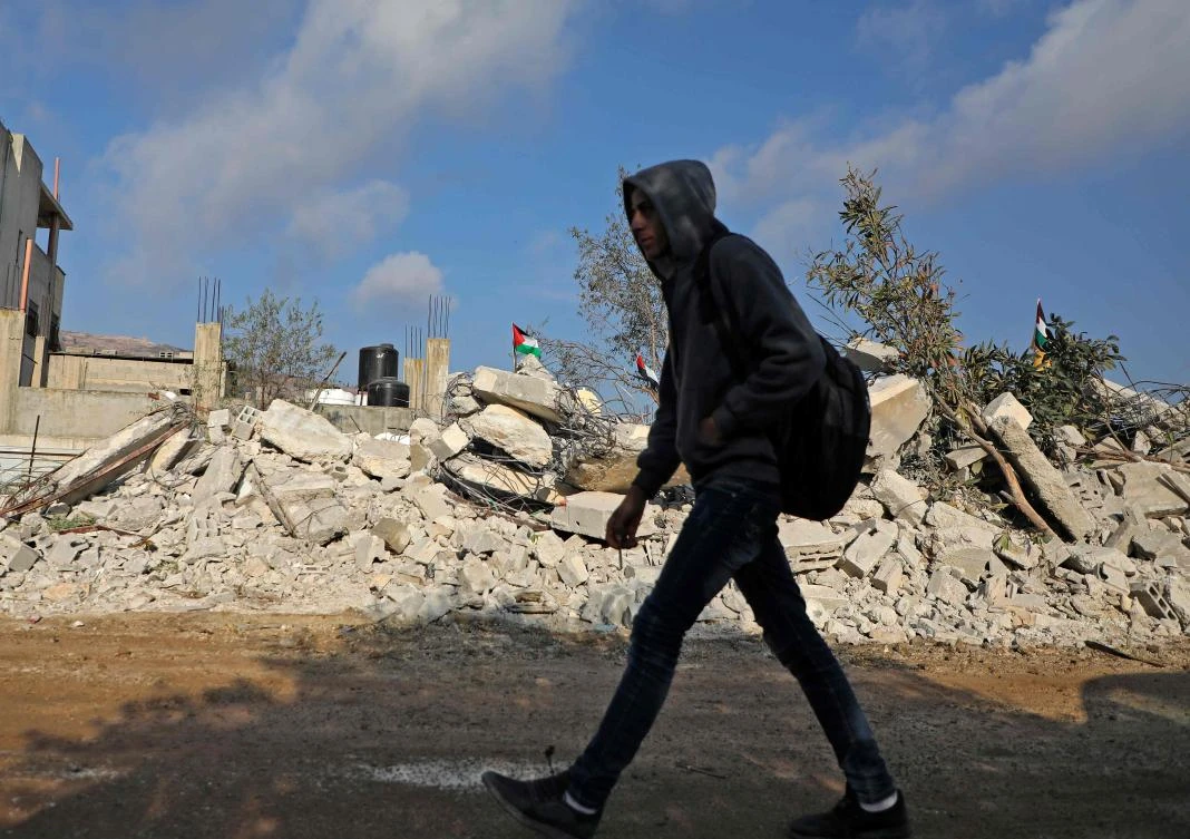 A Palestinian man walks past the remains of the home of Khalil Dweikat, a man accused of an attack that killed an Israeli rabbi earlier this year, in the West Bank village of Rujeib on Nov. 2, 2020, after it was demolished by Israeli soldiers. (AFP)