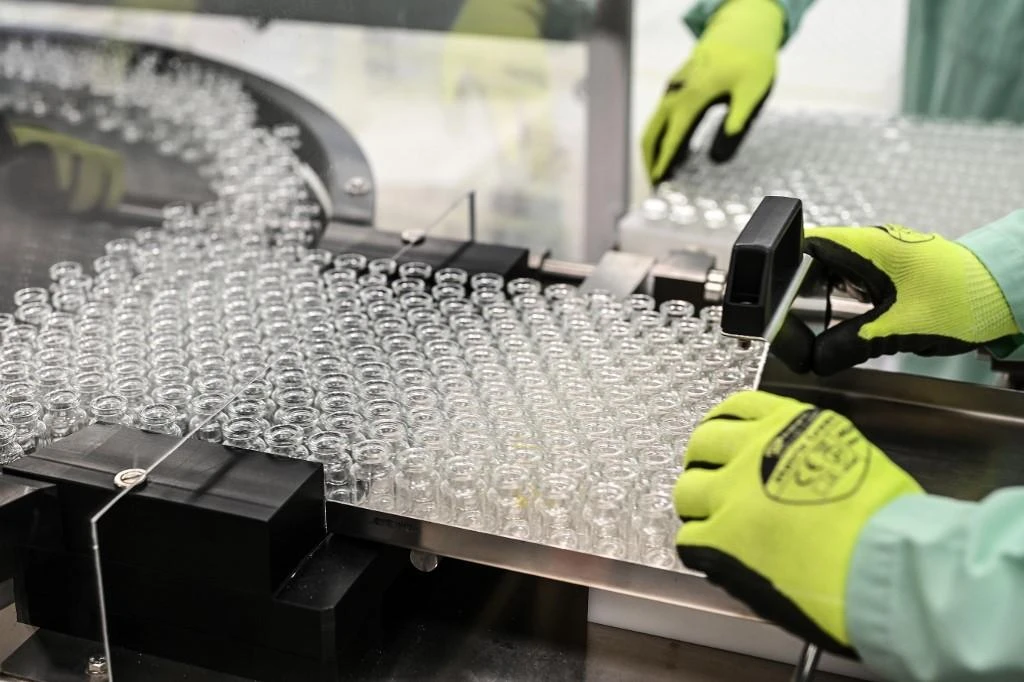 Above, a laboratory technician handles vials as part of filling and packaging tests for the large-scale production and supply of the University of Oxford’s COVID-19 vaccine candidate on Sept. 11, 2020. (AFP)
