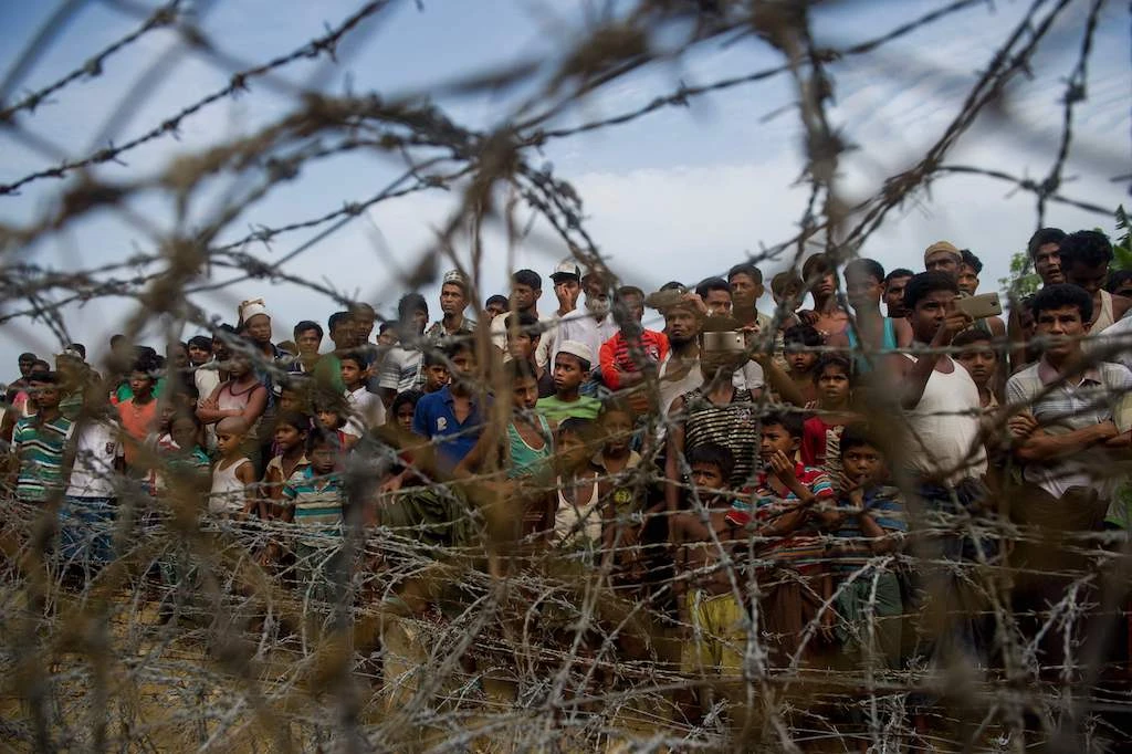 In this file photo taken on April 25, 2018, Rohingya refugees gather in the "no man's land" behind Myanmar's boder lined with barb wire fences in Maungdaw district, Rakhine state bounded by Bangladesh. (AFP)