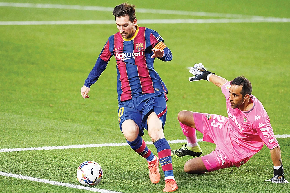 Barcelona’s Argentine forward Lionel Messi and Real Betis’ Chilean goalkeeper Claudio Bravo during their Spanish League match at the Camp Nou stadium in Barcelona. (AFP)