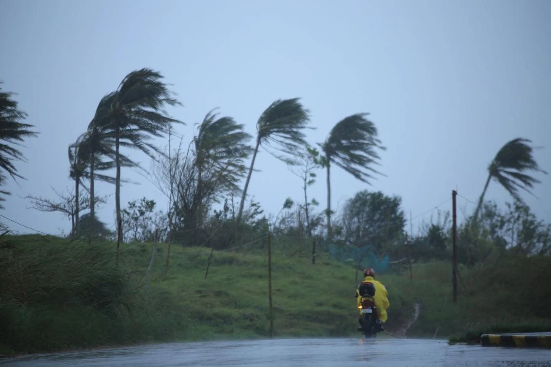 A motorist passes along a street amidst strong winds in Legazpi City, Albay province on Nov. 11, 2020, ahead of the landfall of Tropical Storm Vamco — expected to intensify into a typhoon — in the region devastated by two typhoons in less than three weeks. (AFP)