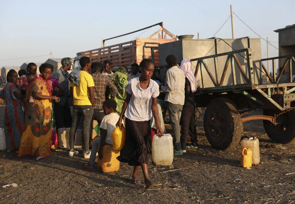 Ethiopian refugees who fled the war in Tigray region line up for water in Qadarif region, eastern Sudan, on Nov. 15, 2020. (AP Photo/Marwan Ali)