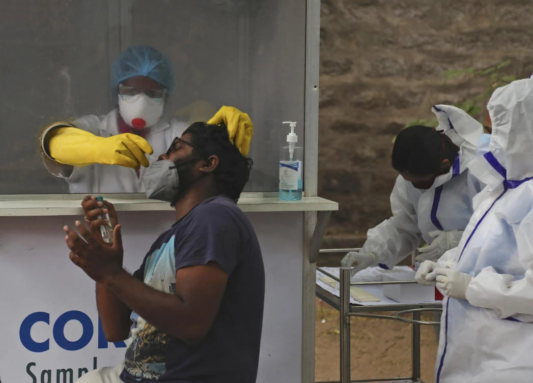 Above, a health worker takes a nasal swab sample of a resident at a COVID-19 testing center in Hyderabad on Nov. 12, 2020. (AP)