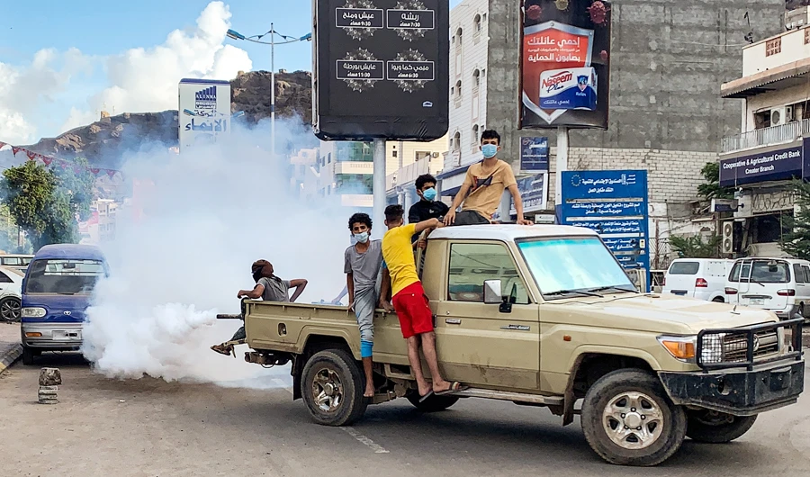 Youths wearing masks as a precaution due to COVID-19 coronavirus disease, sit in the back of a truck carrying out a fumigation in an area in Yemen's southern coastal city of Aden on May 5, 2020, as part of a campaign to prevent the spread of insect-borne diseases such as malaria, dengue fever, and Chikungunya virus amidst the novel coronavirus pandemic.(AFP)