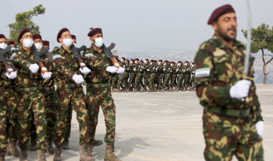 Turkish-backed Syrian rebel fighters, mask-clad due to the COVID-19 coronavirus pandemic, take part in a military parade marking the graduation of a new batch of cadets and attended by officials from the Turkey-backed opposition in the town of Jindayris, in the Afrin region of the northern Syrian rebel-held province of Aleppo, on November 14, 2020. (AFP)