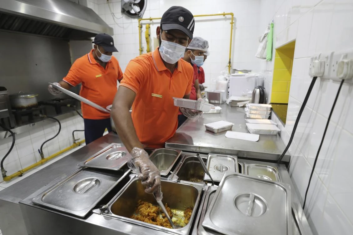 In this industrial underbelly in the suburbs of Dubai, workers methodically assemble packaged takeout meals of biryani rice, dal and brightly colored chicken curry for people in poverty and desperate to eat. (AP)