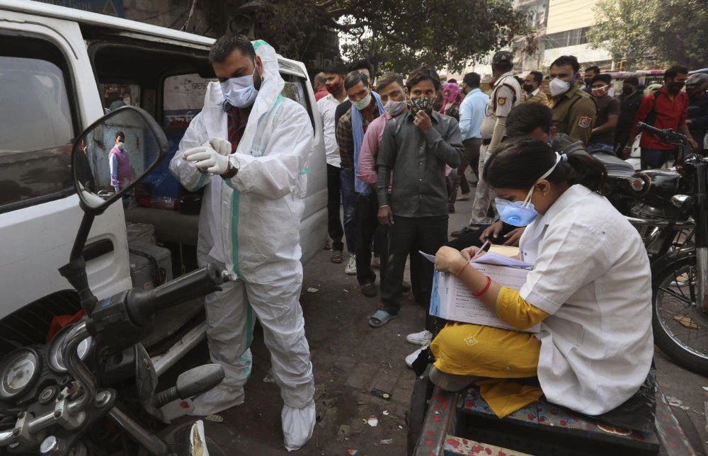 A health worker collects samples to test for COVID-19 in New Delhi, India, on Nov. 19, 2020. (AP Photo/Manish Swarup)