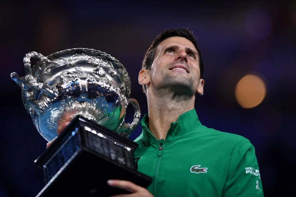 Novak Djokovic holds the Norman Brookes Challenge Cup trophy after beating Dominic Thiem in their men’s singles final of the Australian Open tennis tournament in Melbourne on Feb. 3, 2020. (AFP)