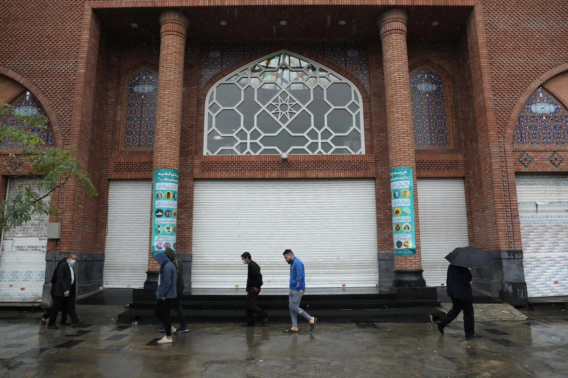 Iranian people wearing protective face masks, walk next to closed shops, as government imposed a full lockdown, amid the spread of the coronavirus disease (COVID-19), in Tehran, Iran November 21, 2020. (Reuters)