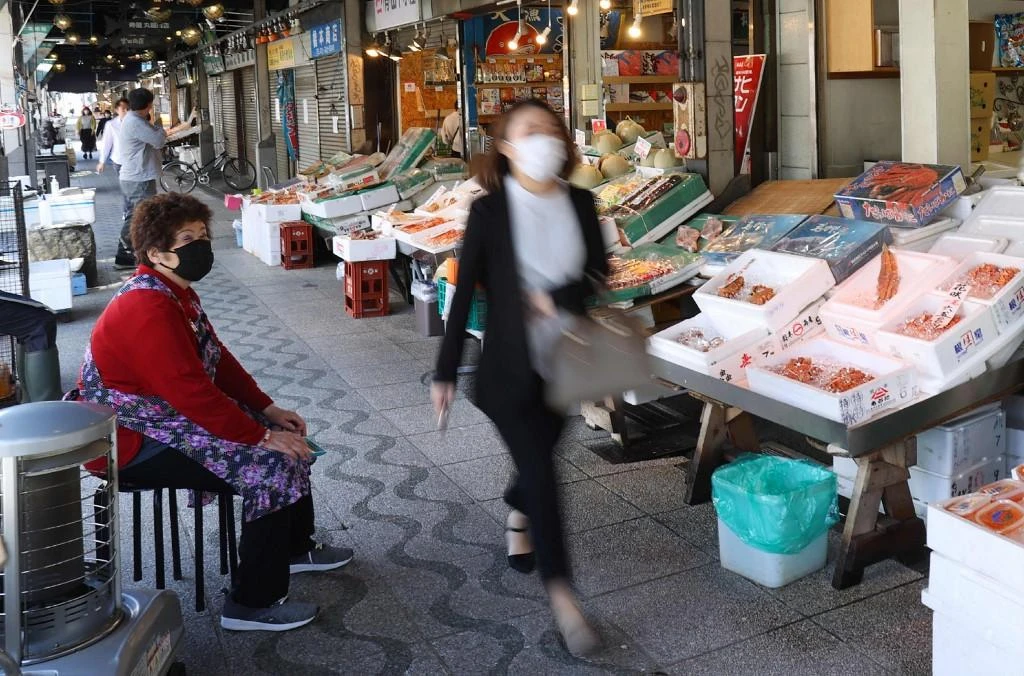 A woman walks at Nijo fish market in Sapporo, one of the cities where Japan’s domestic travel campaign was paused following sharp rises in coronavirus cases. (Jiji Press/AFP)