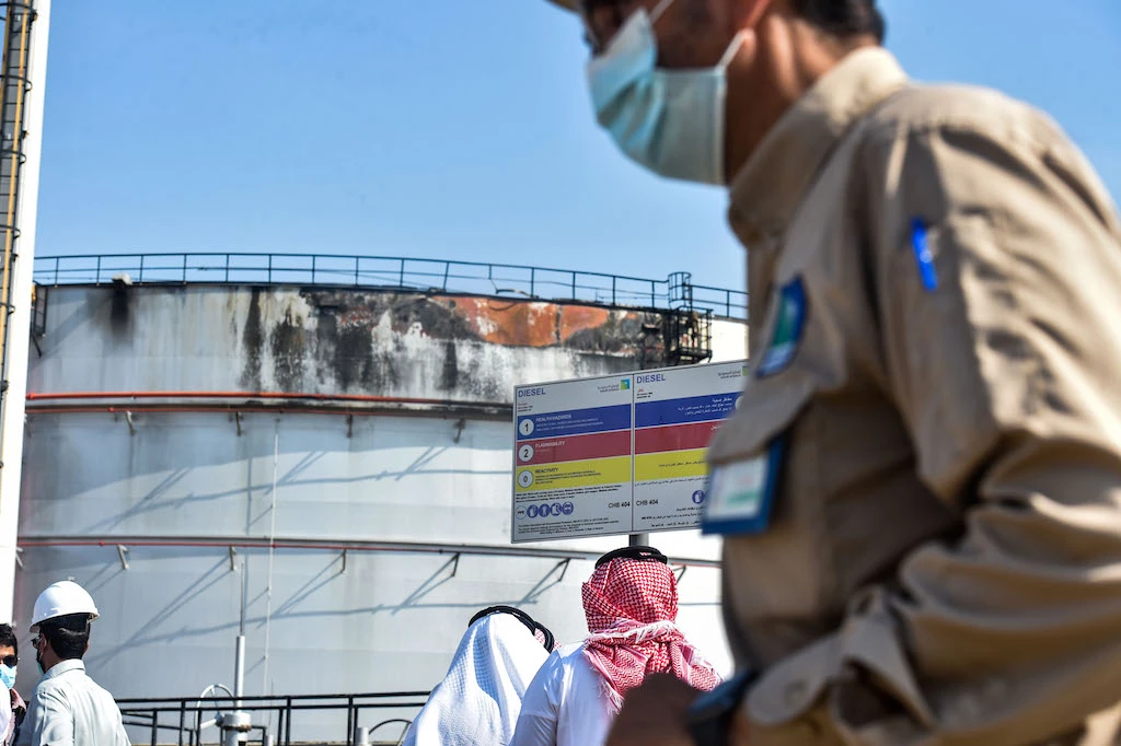 Men look at a damaged silo following an attack at the Saudi Aramco oil facility in Saudi Arabia's Red Sea city of Jeddah on November 24, 2020. (AFP)