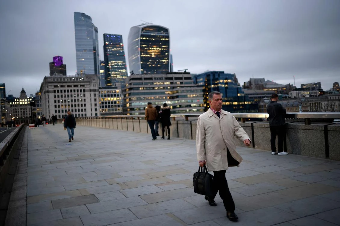 A pedestrian walks over London Bridge away from the City of London in London on November 25, 2020. (AFP)
