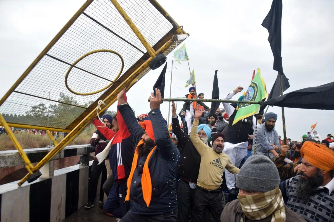 Farmers remove a police barrier blocking a road during a protest march to India’s capital New Delhi against the central government’s recent agricultural reforms, on the outskirts of Ambala on November 26, 2020. (File/AFP)