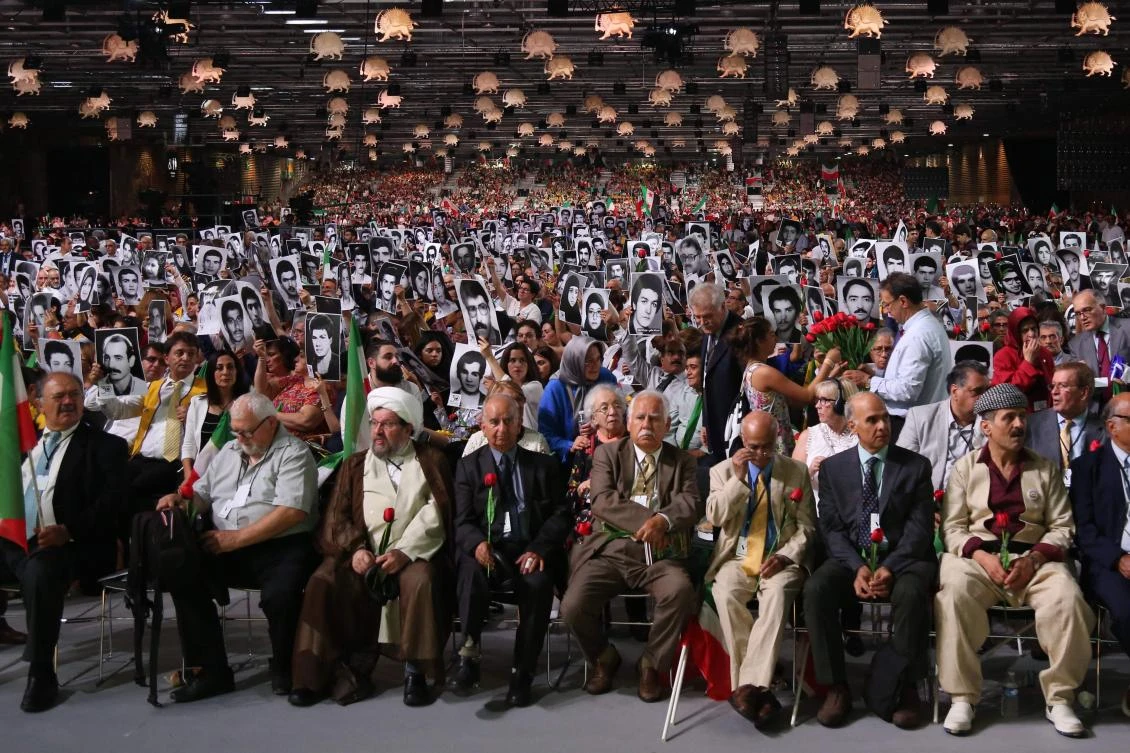 This file photo taken on June 30, 2018 shows people holding pictures of relatives killed by the Mohllas regime, during “Free Iran 2018 — the Alternative” event in Villepinte, north of Paris during the Iranian resistance national council (CNRI) annual meeting. Iranian diplomat Assadollah Assadi and three alleged accomplices face trial in Antwerp on November 27, 2020 over plot to bomb Iran opposition rally of June 2018 in France. (AFP)