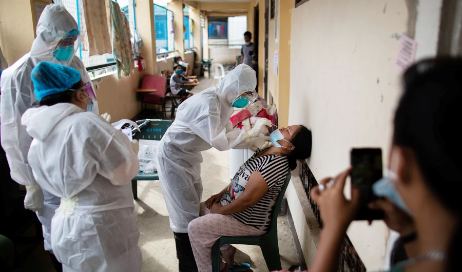 A health worker performs a swab test for detection of the coronavirus disease (COVID-19) at a school turned evacuation center for residents affected by Typhoon Vamco, in Rodriguez, Rizal, Philippines, November 27, 2020. (REUTERS)