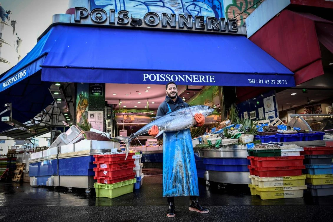 A fishmonger poses outside his shop, in Paris, on November 26, 2020, during France's second lockdown aimed at curbing the spread of Covid-19 (the novel coronavirus). (AFP)