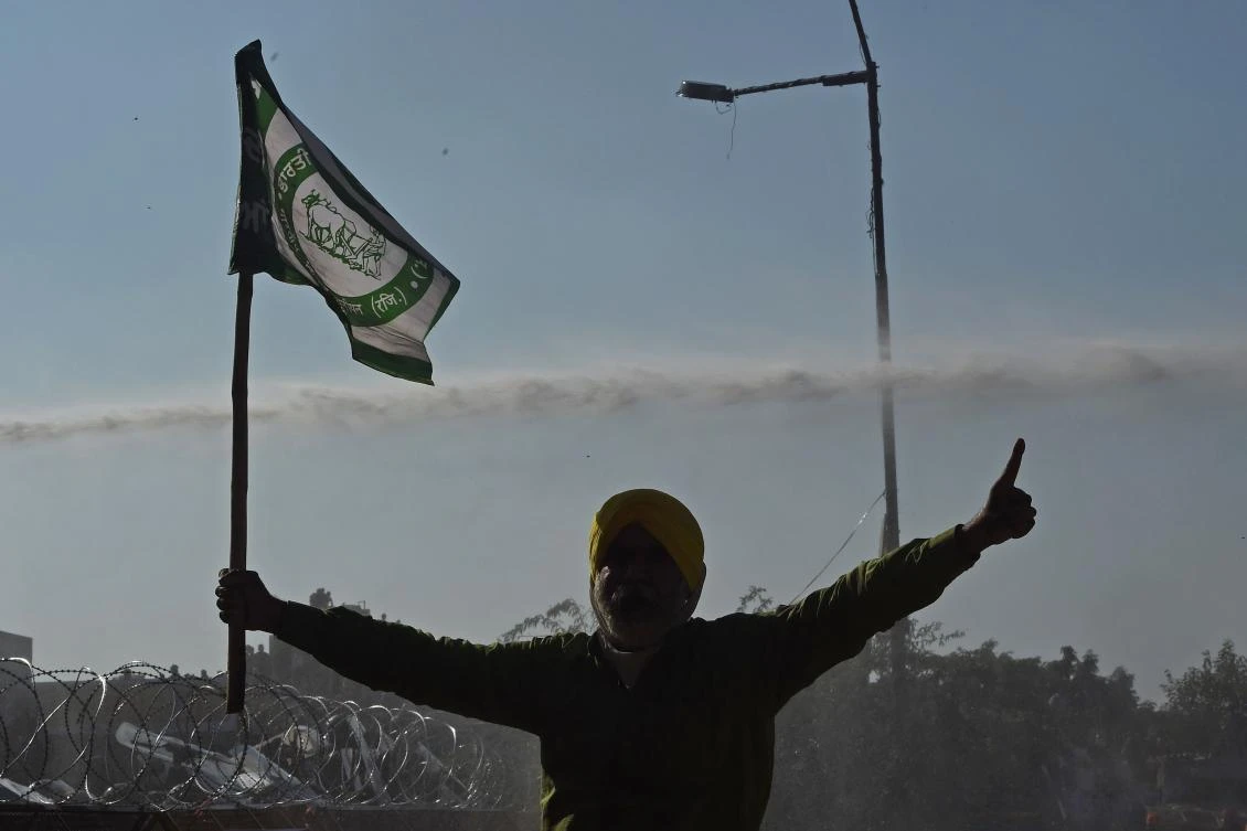 A farmer shouts slogans as police use water canon to disperse farmers at a roadblock as they try to march to New Delhi to protest against the central government’s recent agricultural reforms at the Delhi-Haryana border in Kundli on November 28, 2020. (File/AFP)