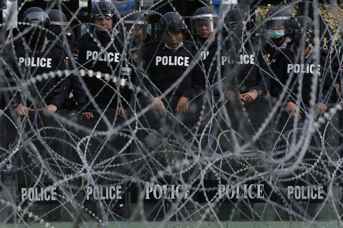Police stand guard behind barbed wire barricading the base entrance of the 11th Infantry Regiment on Nov. 29, 2020 in Bangkok, Thailand. (AP)
