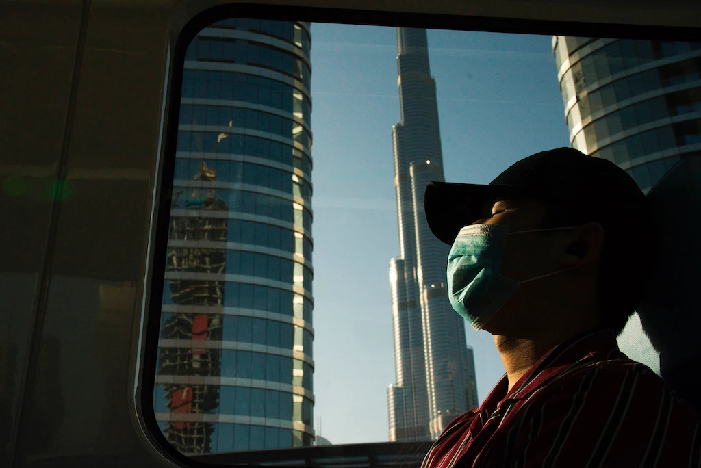 In this April 26, 2020 file photo, a commuter wearing a face mask to help curb the spread of the coronavirus, sleeps aboard the driverless Metro as it passes the Burj Khalifa, the world's tallest building, in Dubai, United Arab Emirates. (AP)