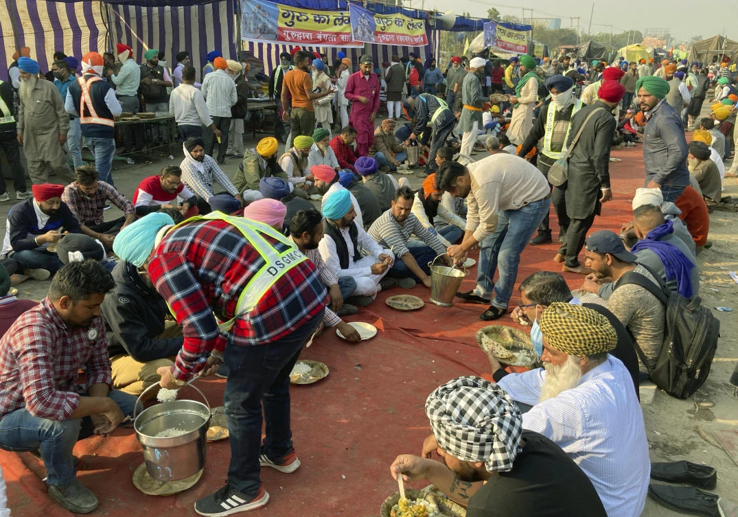 Indian farmers protesting new agriculture eat lunch during a blockade at the Delhi-Haryana state border, Monday, Nov. 30, 2020. (AP Photo/Rishi Lekhi)