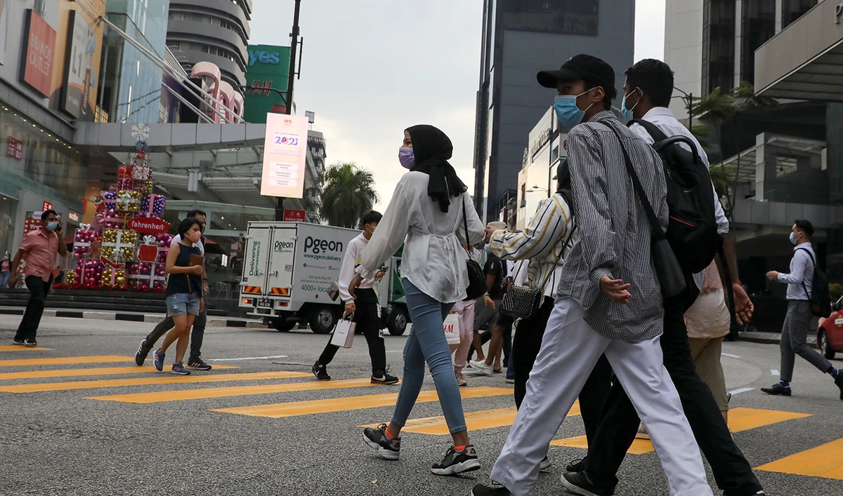 People wearing protective masks cross a street, amid the coronavirus disease (COVID-19) outbreak, in Kuala Lumpur, Malaysia November 30, 2020. (Reuters)