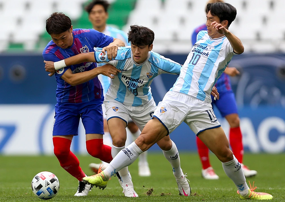 Tokyo’s midfielder Masato Morishige, left, up against Ulsan’s midfielders Lee Sang-Heon, center, and Yun Bit-Garam during their AFC Champions League. (AFP)