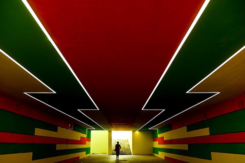 Pedestrians walk through a underpass painted by local artist Zejnije Kastrati, in Pristina on December 11, 2020, amid the COVID-19 outbreak. (AFP)