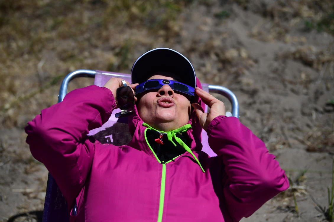 A woman watches the total solar eclipse in Piedra del Aguila, Neuquen province, Argentina on December 14, 2020.RONALDO SCHEMIDT / AFP