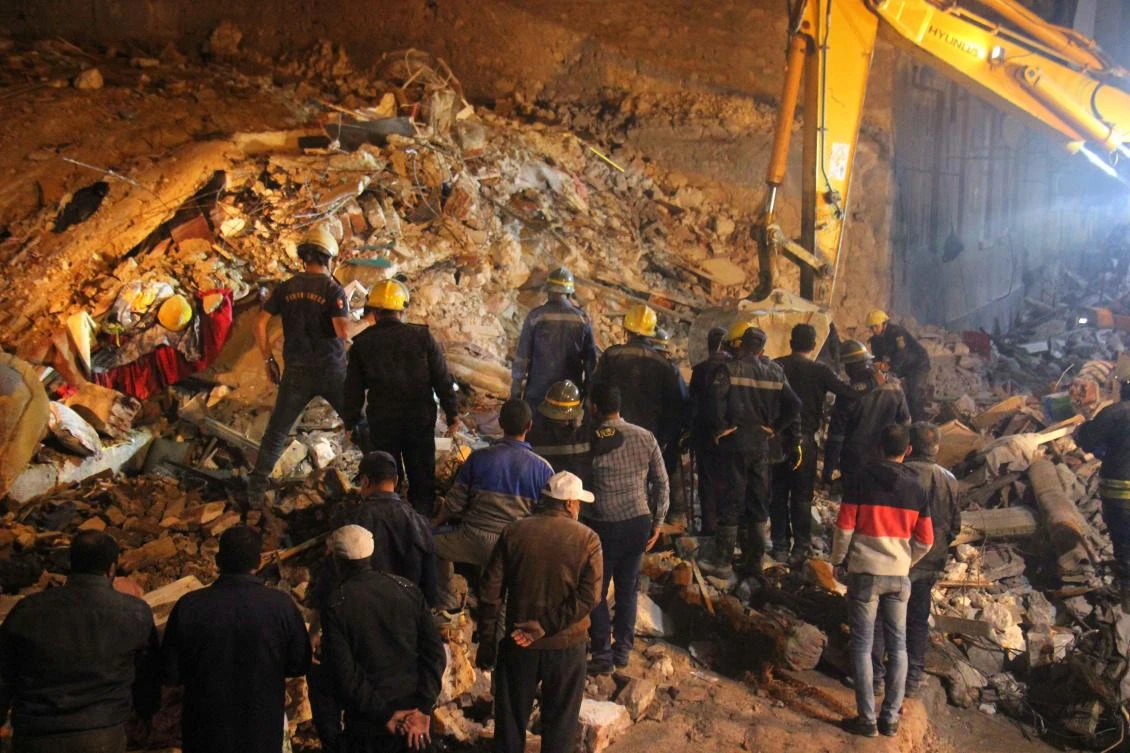 Egyptian rescuers and bystanders are pictured at the site where a dilapidated building collapsed in the Egyptian city of Alexandria, early on December 3, 2020, killing three people. (AFP)