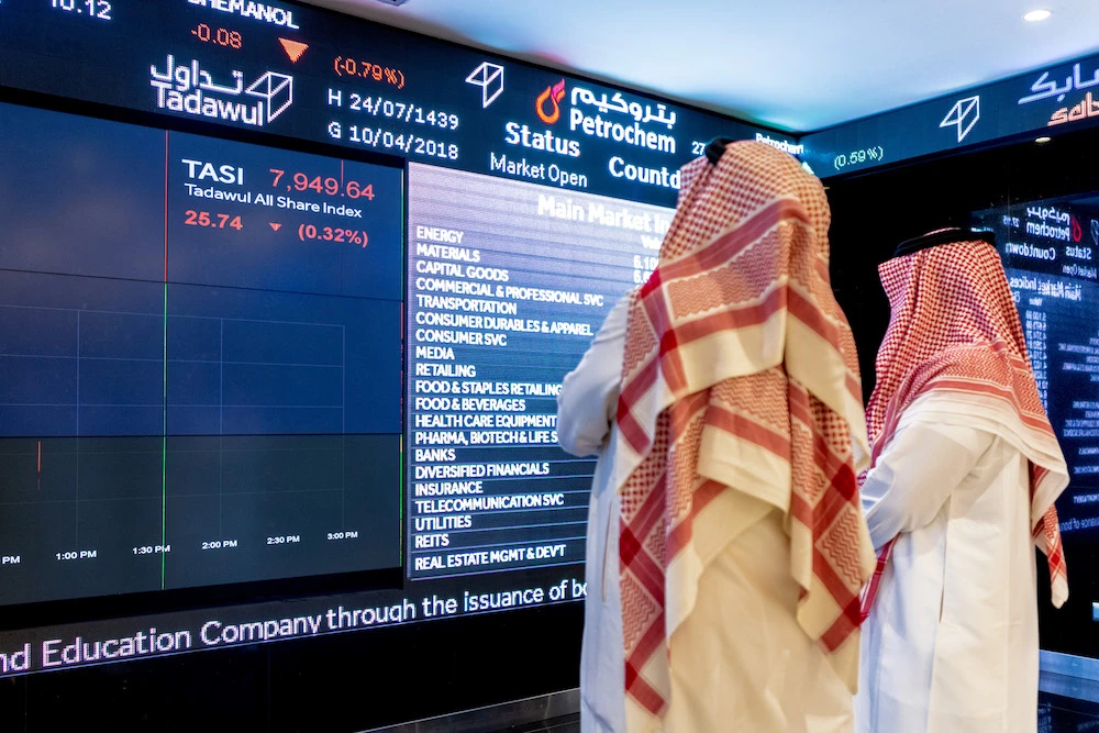 Visitors look at stock price information displayed on a digital screen inside the Saudi Stock Exchange, also known as the Tadawul, in Riyadh, Saudi Arabia, April 10, 2018. (Getty Images)