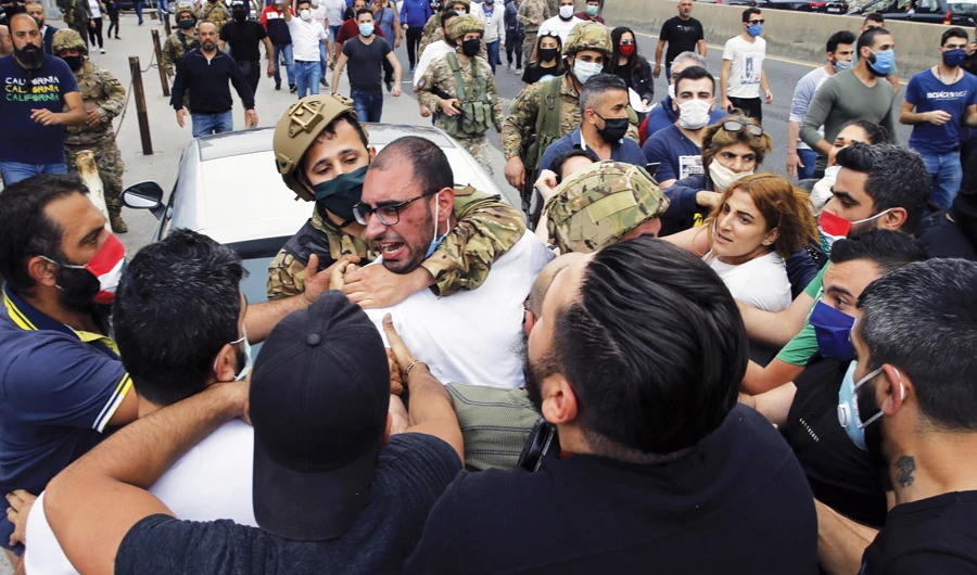 Anti-government protesters scuffle with Lebanese army soldiers in the town of Zouk Mosbeh, north of Beirut. (AP/File)