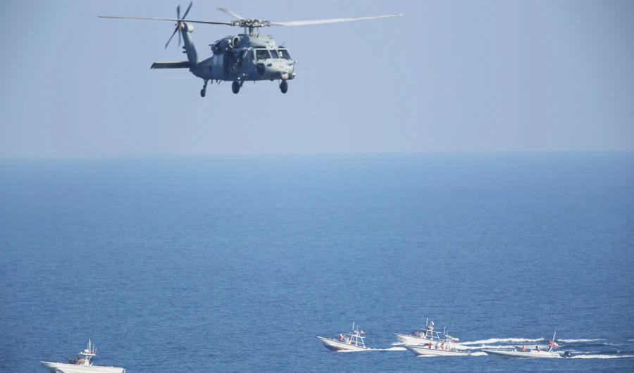 A US MH-60 Seahawk helicopter flies over Revolutionary Guard patrol boats in the Strait of Hormuz, as tensions run high over the Iranian nuclear program. (AP)